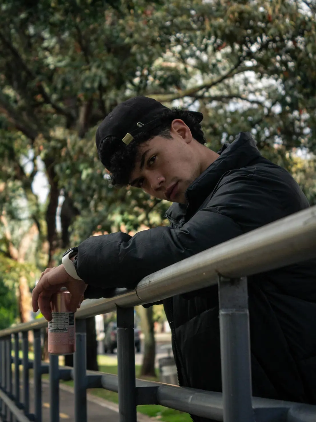 David Vega con gorra apoyado en una baranda en el parque