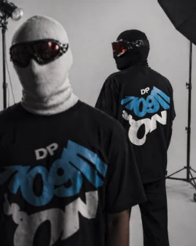 Dos modelos con pasamontañas y camisetas negras con el gráfico DP en estudio